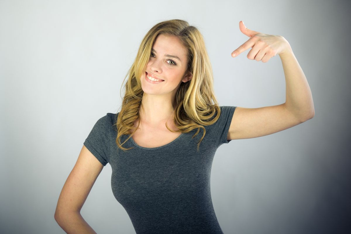 attractive woman on plein background shot in studio with soft lights with an interesting expression and dramatic lighting